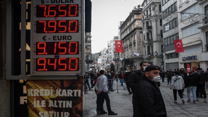 People walk past a currency exchange board on March 22, 2021, in Istanbul, Turkey. Turkey's lira plummeted as much as 15% to hit 8.39 per US dollar in the first day of trading after Turkey's President Recep Tayyip Erdogan replaced central bank governor Naci Agbal, triggering fears of another currency crisis.