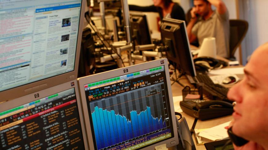 A trader looks at his monitors as he works in a dealing room in Tel Aviv on October 12, 2008 in Tel Aviv, Israel.