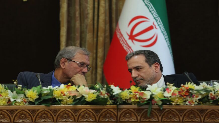 A handout picture provided by the Iranian presidency on July 7, 2019, shows (L to R) Iran's government spokesman Ali Rabiei and Deputy Foreign Minister Abbas Araghchi speaking to each other during a joint press conference at the presidential headquarters in the capital, Tehran, on July 7, 2019. Iran will begin enriching uranium beyond a 3.67% cap set by a landmark nuclear deal "in a few hours," the Islamic Republic's Atomic Energy Organization spokesman Behrouz Kamalvandi said on July 7, 2019. 