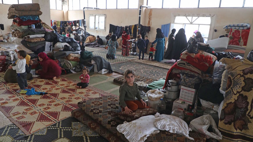 Syrians sit inside a prayer hall of a cemetery where displaced families took refuge in the town of Sarmada in Syria's northwestern Idlib province, on Feb. 23, 2020.