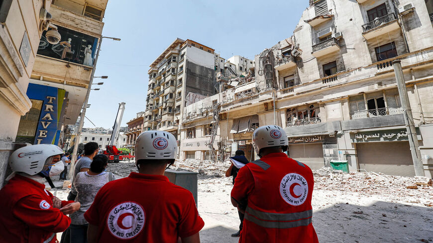 Egyptian Red Crescent members gather at the scene of a building collapse along Kasr el-Nile street in downtown district in Cairo, Egypt, Aug. 15, 2020.