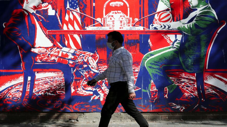 A man walks past a mural painted on the outer walls of the former US Embassy in the Iranian capital, Tehran, on Sept. 29, 2020.