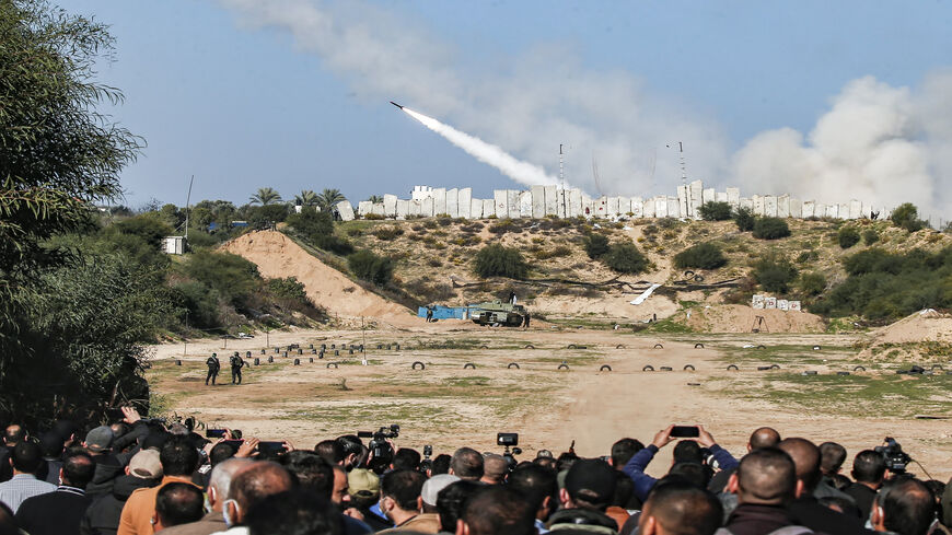 People watch as rockets are fired during a military drill by Palestinian Islamist movement Hamas and other Palestinian armed factions, Gaza City, Gaza Strip, Dec. 29, 2020.