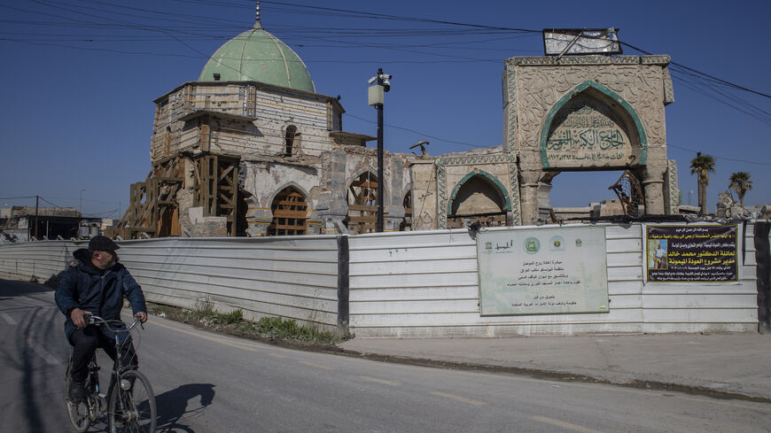 A man on a bicycle rides past Al-Nuri Mosque, which is under reconstruction after it was destroyed in the war against ISIS, on Feb. 28, 2021 in Mosul, Iraq. 