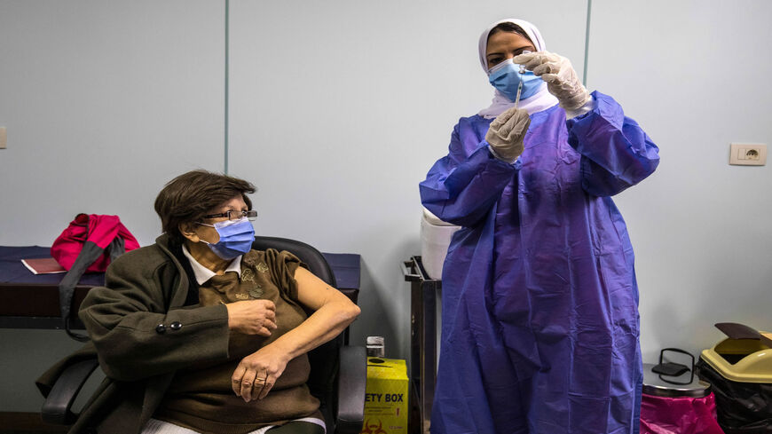 An Egyptian medical worker administers a dose of the AstraZeneca coronavirus vaccine on the first day of vaccination, Cairo, Egypt, March 4, 2021.