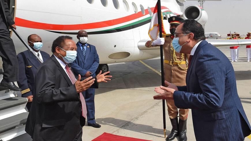 Egyptian Prime Minister Mustafa Madbouly (R) welcomes his Sudanese counterpart Abdalla Hamdok upon his arrival in Cairo, Egypt, March 11, 2021.