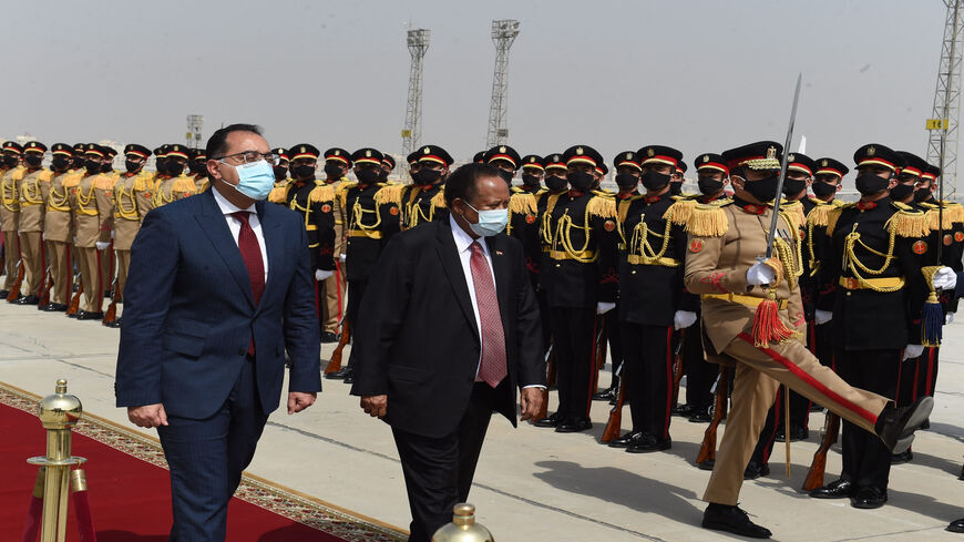 Egyptian Prime Minister Mostafa Madbouly (L) welcomes his Sudanese counterpart Abdalla Hamdok upon his arrival in Cairo, Egypt, March 11, 2021.