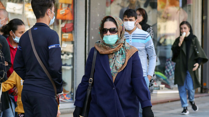 Iranians wearing face masks walk in a street in the capital Tehran, on March 29, 2021, as rising COVID-19 infections fueling fears of a fourth wave of the pandemic prompted a closure of cinemas. 