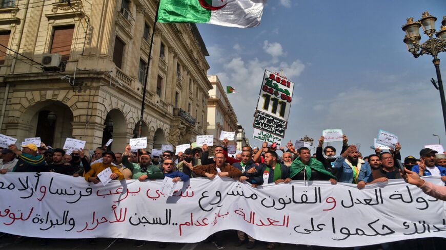 Algerians carry a large banner during an anti-government demonstration in the capital, Algiers, on April 2, 2021.