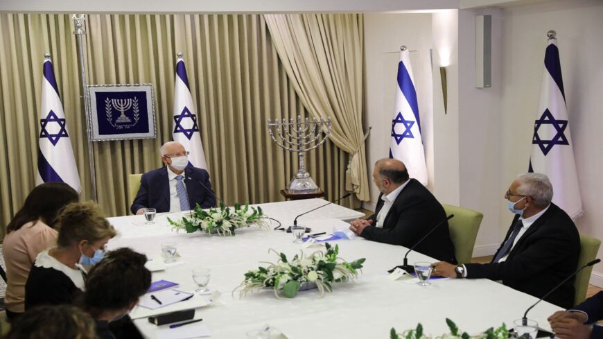 Israeli Arab politician, leader of the United Arab List Mansour Abbas (R) attends consultations with Israeli President Reuven Rivlin (L) on who might form the next coalition government, at the president's residence in Jerusalem, on April 5, 2021.