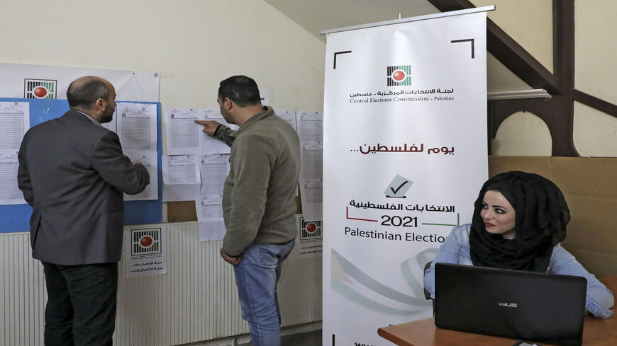 Employees of the Palestinian Central Elections Commission display electoral lists ahead of the upcoming general elections, at the commission's district offices, Hebron, West Bank, April 6, 2021.