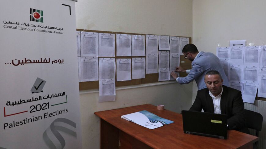 Employees of the Palestinian Central Elections Commission display electoral lists ahead of the upcoming general elections, at the commission's district offices in the city of Hebron in the Israeli-occupied West Bank, on April 6, 2021. Palestinian legislative elections are scheduled for May 22, with a presidential vote to follow on July 31.