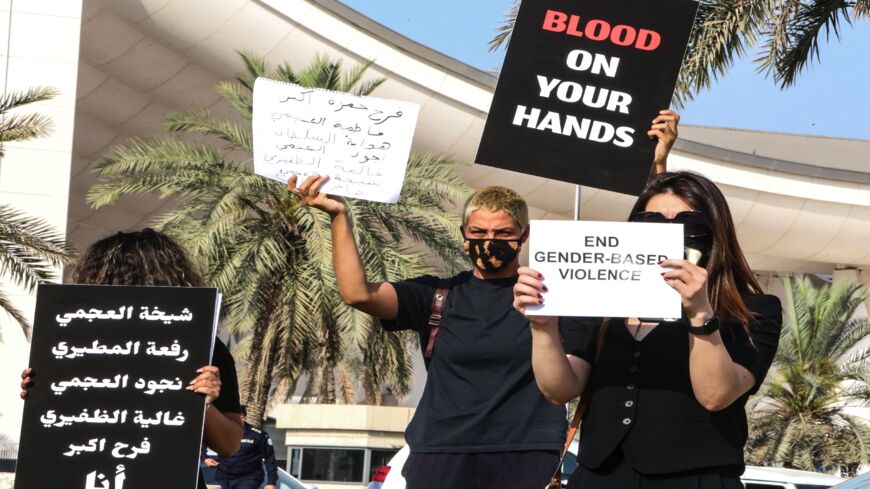 Kuwaiti women raise placards during a rally to denounce violence against women, outside the National Assembly in the capital, Kuwait City, on April 22, 2021. The women demonstrated after Farah Hamaza, a 32-year-old Kuwaiti woman, was recently killed by a young man despite her filing several complaints against him.