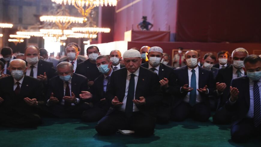 In this handout picture released by the Turkish presidential press office, Turkey's President Recep Tayyip Erdogan (C) and invited guests attend Friday prayers at Hagia Sophia Grand Mosque during the building's first official prayers after being reconverted into a mosque on July 24, 2020, in Istanbul, Turkey.