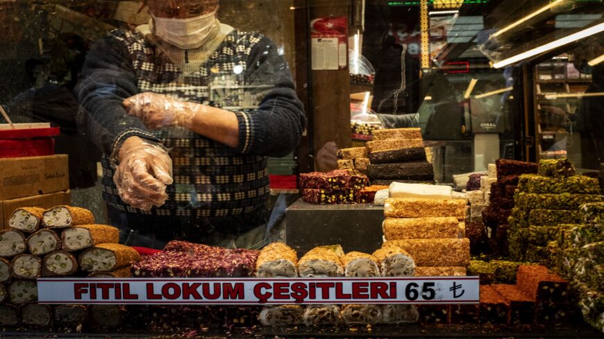 A man wearing a protective face mask and gloves and working behind a plastic shield waits to serve customers on a busy market street on April 09, 2021, in Istanbul, Turkey. The country announced more than 55,000 new COVID-19 cases in the past 24 hours, a new daily record since the start of the pandemic. Fears are growing that coronavirus cases will continue to rise as the country prepares to celebrate the holy month of Ramadan starting on April 13. 