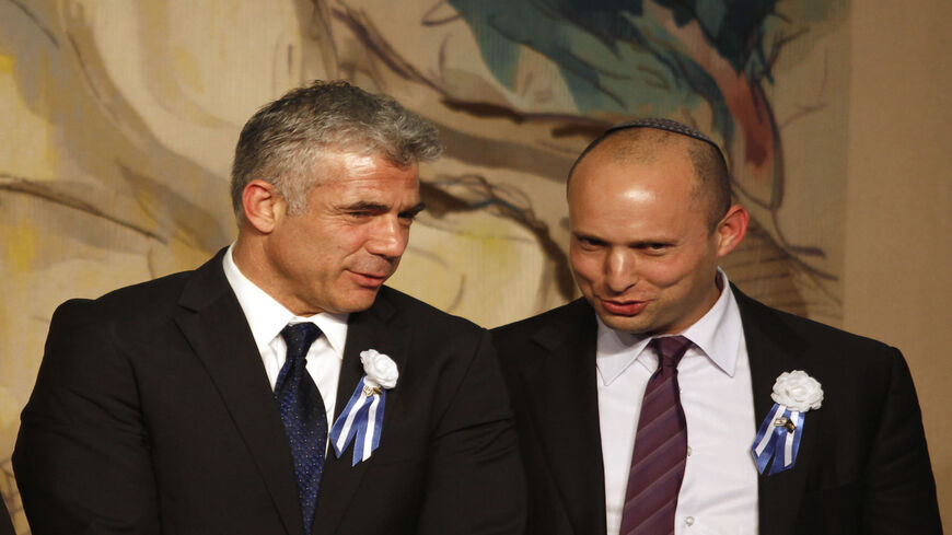 Israeli politician Yair Lapid (L), leader of the Yesh Atid party, speaks to Naftali Bennett, head of the Israeli hard-line national religious party the Jewish Home, during a reception marking the opening of the 19th Knesset, Jerusalem, Feb. 5, 2013.