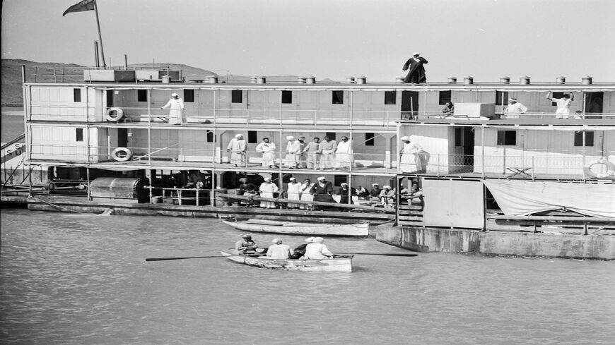 A Sudanese police officer is rowed to a passenger steamboat that has just arrived from Aswan at the Sudanese frontier town of Wadi Halfa on the River Nile, circa 1950.