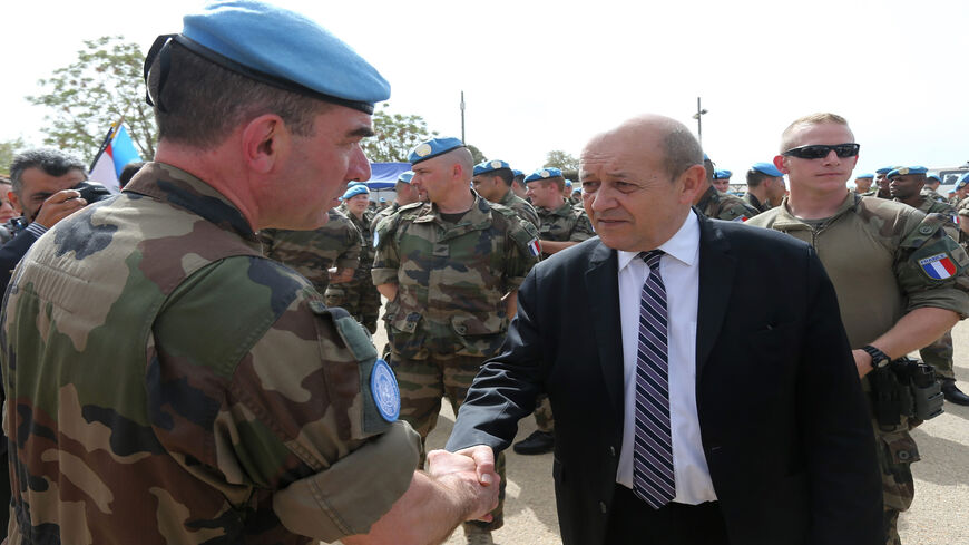 French Defense Minister Jean-Yves Le Drian shakes hands with a French soldier of the United Nations Interim Forces in Lebanon during a visit to the contingent headquarters in the southern village of Deir Kifa, Lebanon, April 20, 2015.