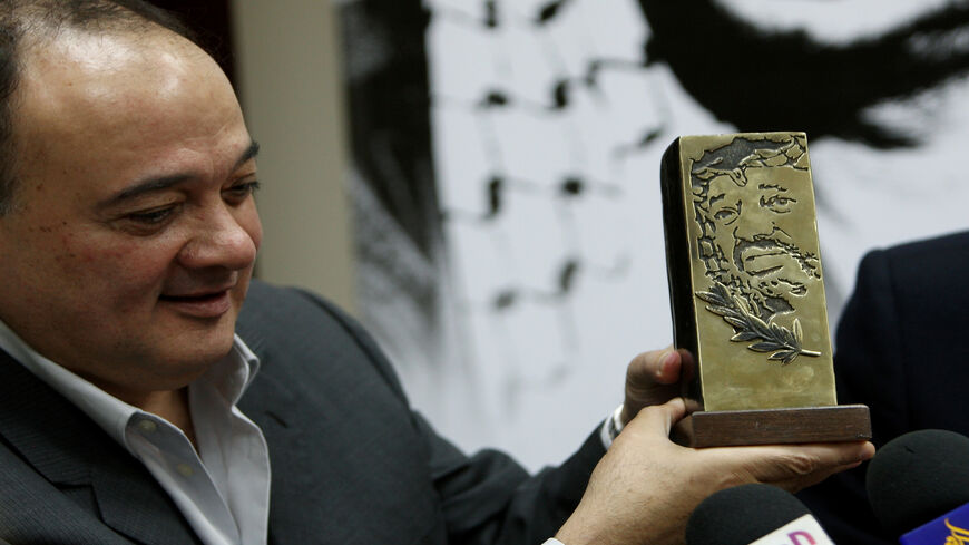 Former Palestinian Foreign Minister Nasser al-Qudwa, a nephew of Yasser Arafat, holds a slab bearing an engraving of a portrait of the late Palestinian leader during a press conference he held in Ramallah, West Bank, Nov. 8, 2009.