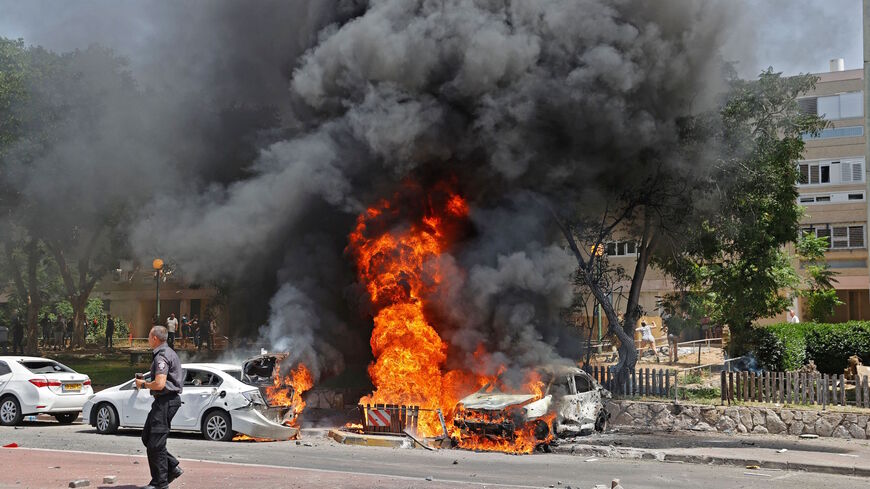 Vehicles are pictured ablaze after a rocket launched from the Gaza Strip, controlled by the Palestinian Hamas movement, landed in the southern Israeli city of Ashkelon on May 11, 2021.