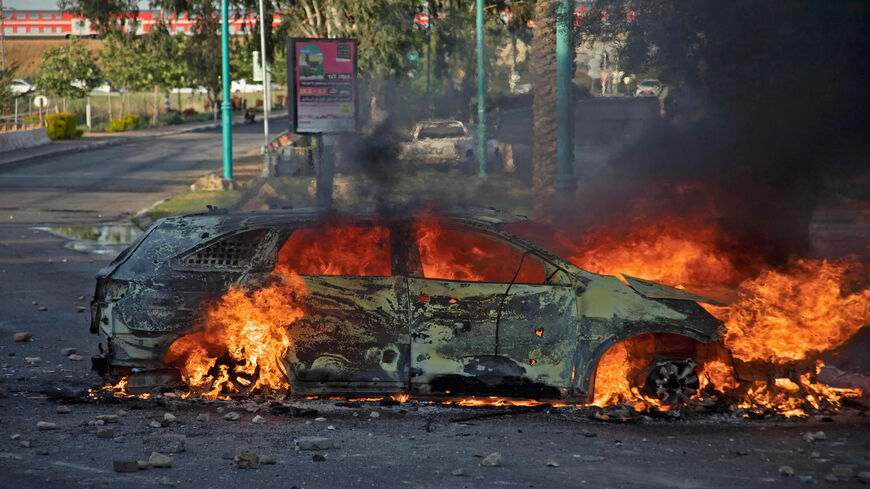 An Israeli police car burns after an Arab Israeli demonstration following the funeral of Mousa Hassouna in the central city of Lod, near Tel Aviv, Israel, May 11, 2021.