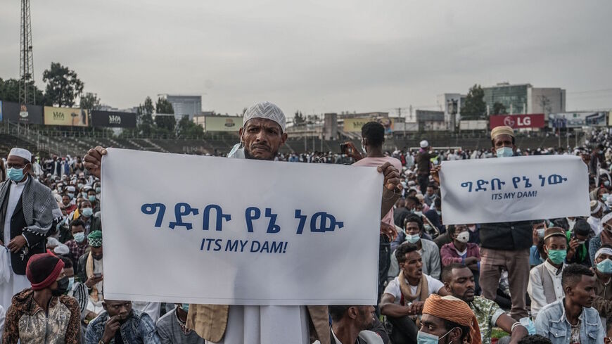 People hold placards to express their support for Ethiopia's mega-dam on the Blue Nile River as faithfuls gather to attend the Eid al-Fitr morning prayer sermon at a soccer stadium in Addis Ababa, Ethiopia, on May 13, 2021 as Muslims across the globe mark the end of the Holy month of Ramadan. 