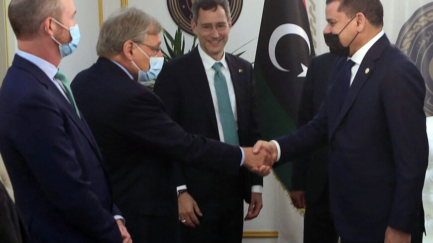 Libyan Prime Minister Abdulhamid Dbeibeh (R) shakes hands with a US State Department official as senior official Joey Hood (C) watches, during a visit by US officials to Libya in a show of support for the country's transitional government, Tripoli, Libya, May 18, 2021.