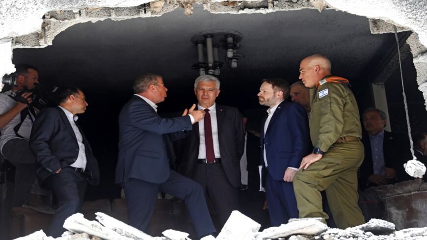 Slovak Foreign Minister Ivan Korcok (C) and his counterpart from the Czech Republic, Jakub Kulhanek (2nd R), listen to remarks by their Israeli counterpart, Gabi Ashkenazi (L), during their visit to a building that was hit by a rocket fired by Palestinian militants from the Gaza Strip, in the Israeli city of Petah Tikva on May 20, 2021.