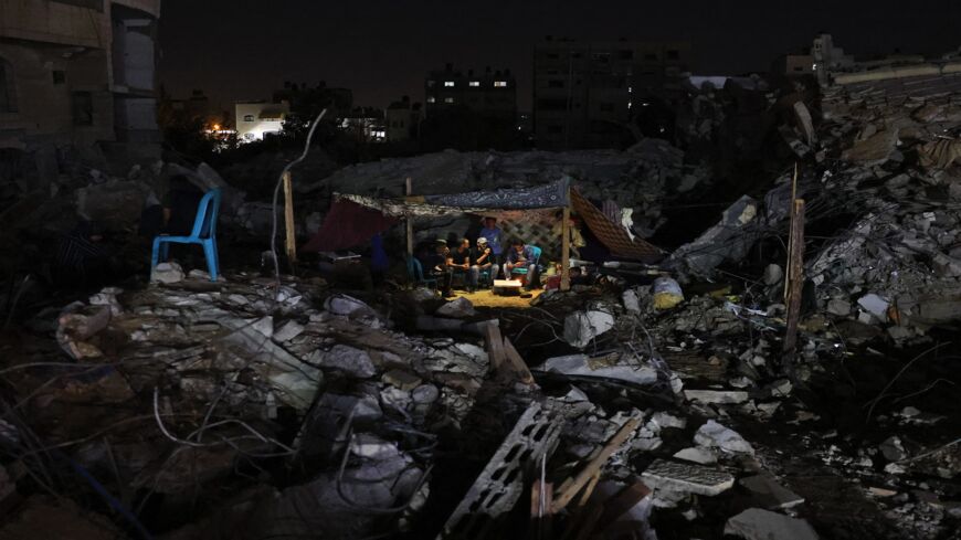 Palestinians sit in a tent that has been set up on top of the ruins of a building destroyed in recent Israeli airstrikes, in Gaza City, on May 24, 2021. A cease-fire was reached late last week after 11 days of deadly violence between Israel and the Hamas movement, which runs Gaza.