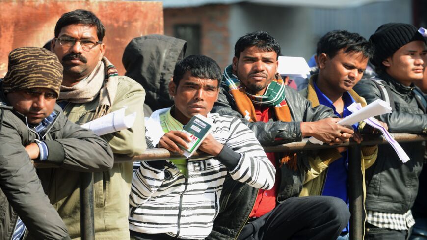 Nepalese migrant workers queue to receive official documents in order to leave Nepal from the Labor Department in Kathmandu on January 27, 2014. Nearly 200 Nepali migrant workers died in Qatar in 2013, figures that highlight the grim plight of laborers in the Gulf nation.
