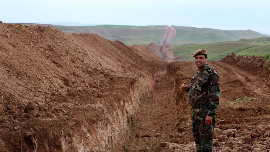 A member of Iraqi security forces looks on during the digging operations to build a trench on the northern Iraqi border with Syria to prevent people from crossing over into Iraq's autonomous Kurdistan region, on April 13, 2014 in Zakho.