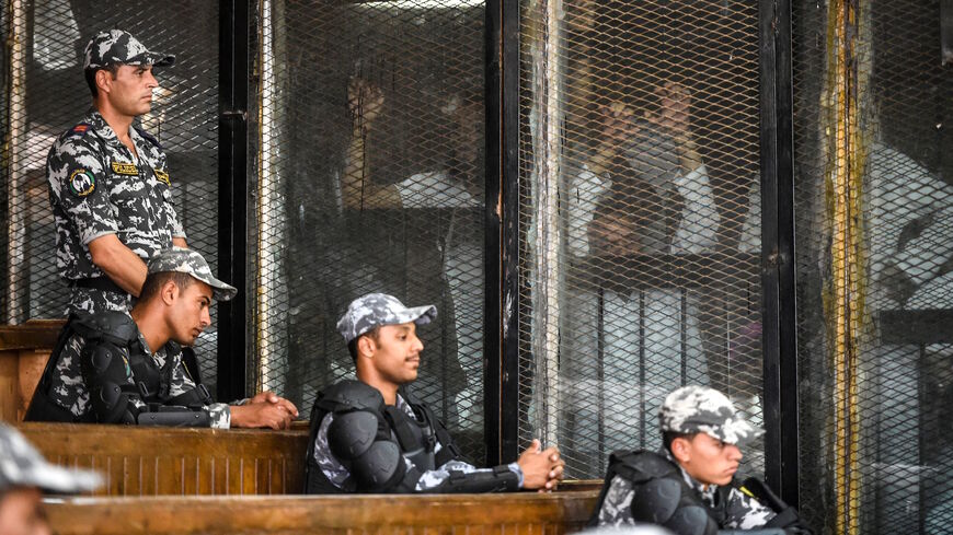 Members of Egypt's banned Muslim Brotherhood are seen inside a glass dock during their trial in the capital Cairo on July 28, 2018. 