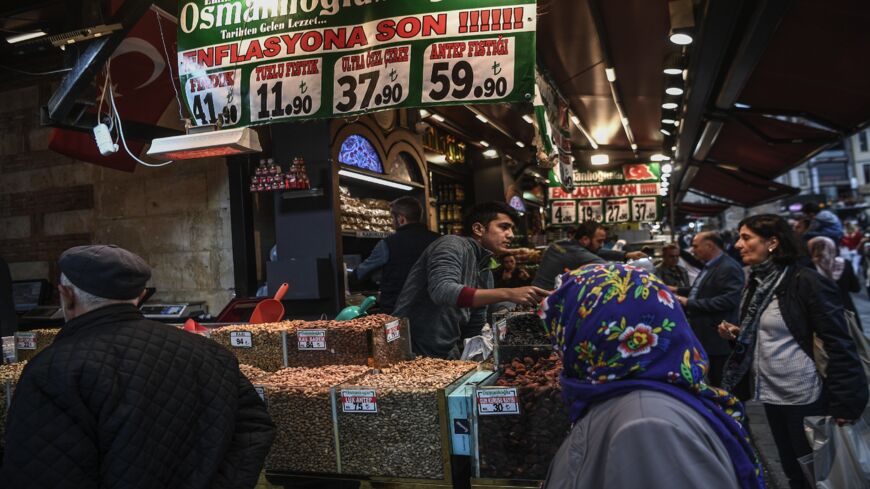 Vendors sell dry food as people shop by a banner reading "No to Inflation" near the New Mosque area in Istanbul's Eminonu district on Nov. 6, 2018. Inflation in Turkey surged to over 25% in October from the same period the year earlier, the highest annual rate for over 15 years, official statistics showed on Monday. Prices have soared in Turkey over the last months as the lira came under pressure, stoking fears over the long-term economic health of the country.