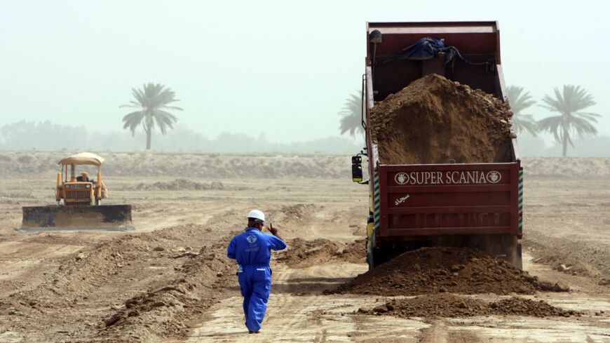 Workers prepare a site for constructing small residential units, 30 kilometers south of Baghdad, on June 1, 2011.