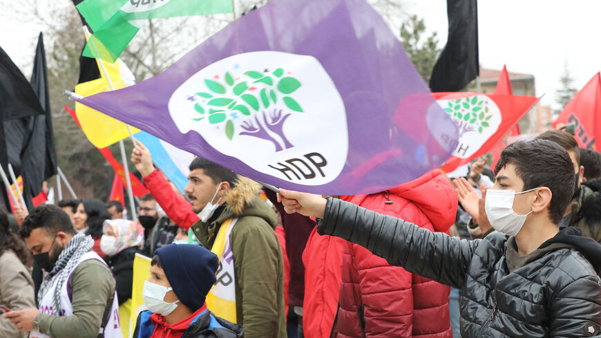 A boy waves a flag as supporters of Pro-Kurdish Peoples' Democratic Party (HDP) shout slogans during a rally as part of Nowruz (Newroz), or Kurdish New Year, celebrations in Ankara, on March 21, 2021.