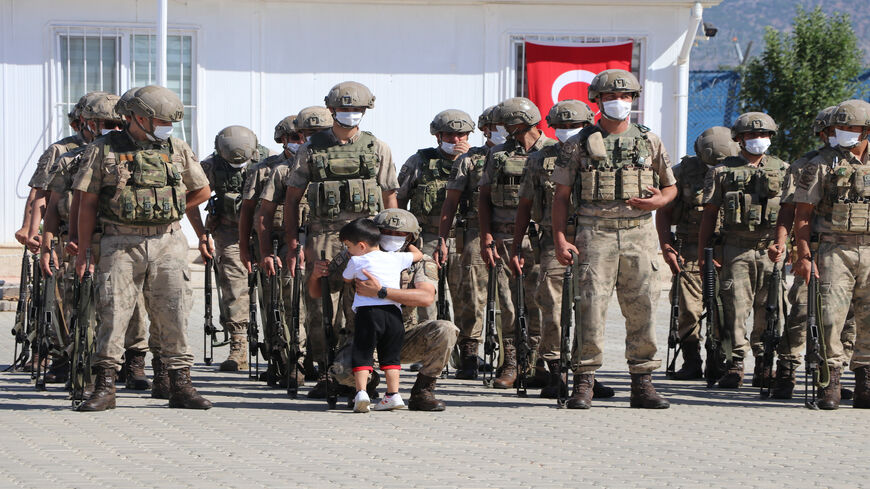 A child hugs his father who is part of a group of soldiers at a farewell ceremony ahead of going for their duty in Jarablus district in Syria, which was cleared from the Islamic State, at the Gaziantep Gendarmerie General Command in Gaziantep, Turkey, June 7, 2021.