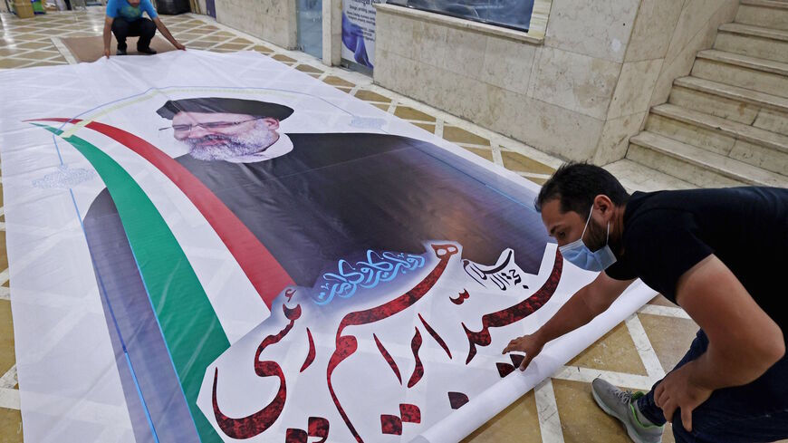 A worker prepares a campaign banner of presidential candidate Ebrahim Raisi at a print shop in the Iranian capital Tehran on June 7, 2021.  