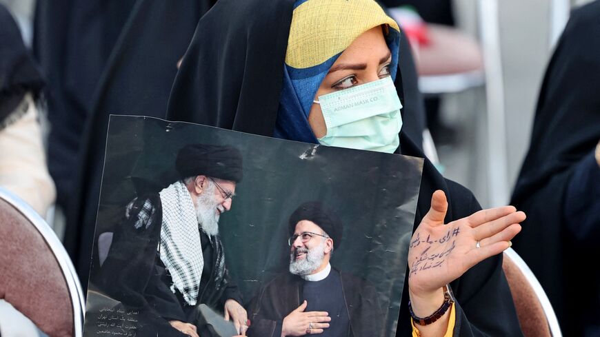 Raisi supporter holds his picture