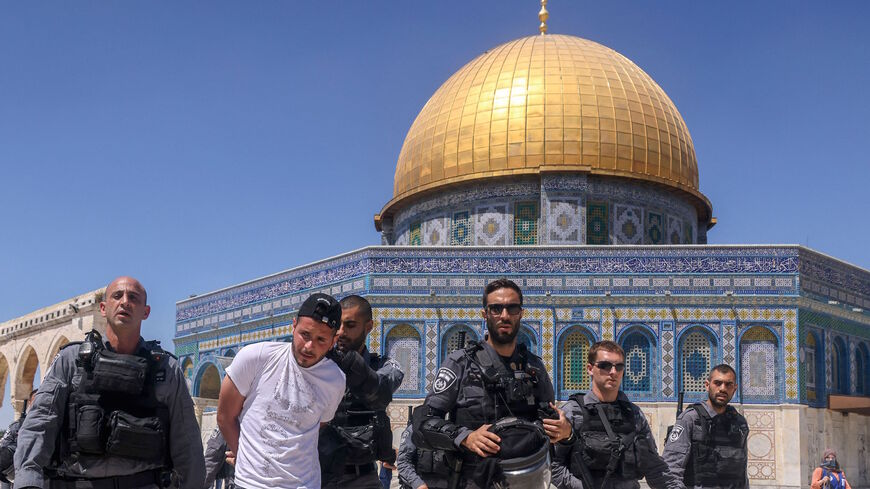 Members of the Israeli security forces detain a Palestinian man in front of the Dome of the Rock mosque following Friday prayers in Jerusalem's Al-Aqsa mosque complex, on June 18, 2021, as Palestinians protested in response to chants by Israeli ultranationalists targeting Islam's Prophet.