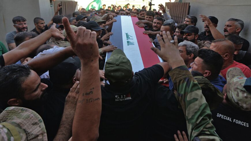 Iraqi mourners attend the funeral of a fighter of the Hashid Shaabi paramilitary alliance following US airstrikes on the Syrian-Iraqi border, on June 28, 2021, in the northern Ninevah province.