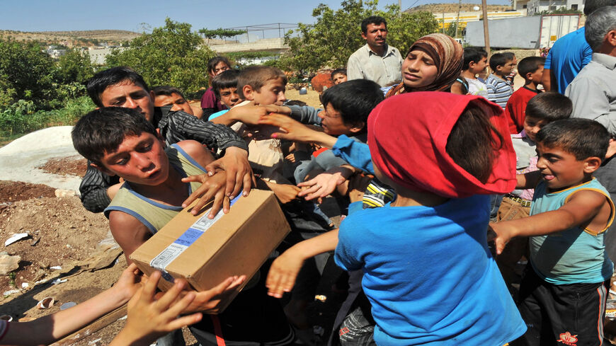 Syrian children fight over goods taken from a truck that rebels captured at Bab al-Hawa border crossing with Turkey, near Aleppo, Syria, July 20, 2012.