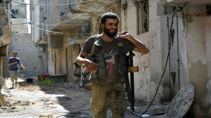 Opposition fighters belonging to Ansar al-Islam and Ahrar ash-Sham walk on a street next to the frontline that divides rebel and regime-controlled areas in the Tadamon neighborhood, south of Damascus, and near the Yarmuk Palestinian refugee camp, Syria, June 15, 2015.