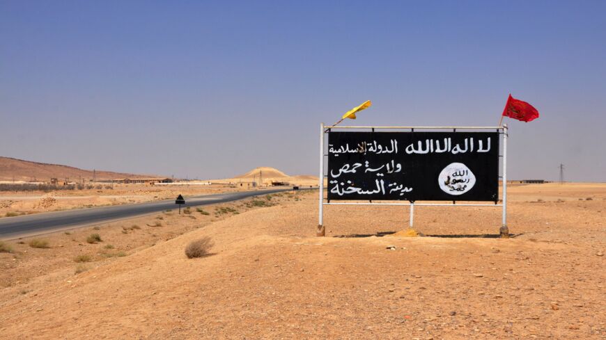 A general view taken on August 13, 2017, shows an Islamic State group poster in the central Syrian town of Al-Sukhnah.