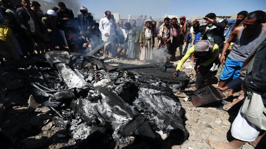Yemenis inspect the burning wreckage of a drone in the country's capital, Sanaa, on Oct. 1, 2017. 