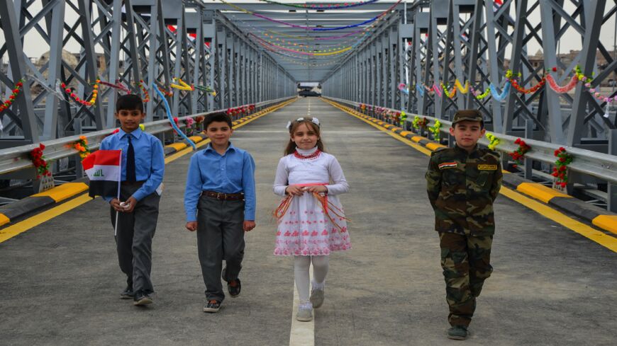 Iraqi children are seen at the Ninevah Bridge, previously known as Mosul's Old Bridge, during an inauguration ceremony following its reconstruction in the city of Mosul on March 14, 2018. 