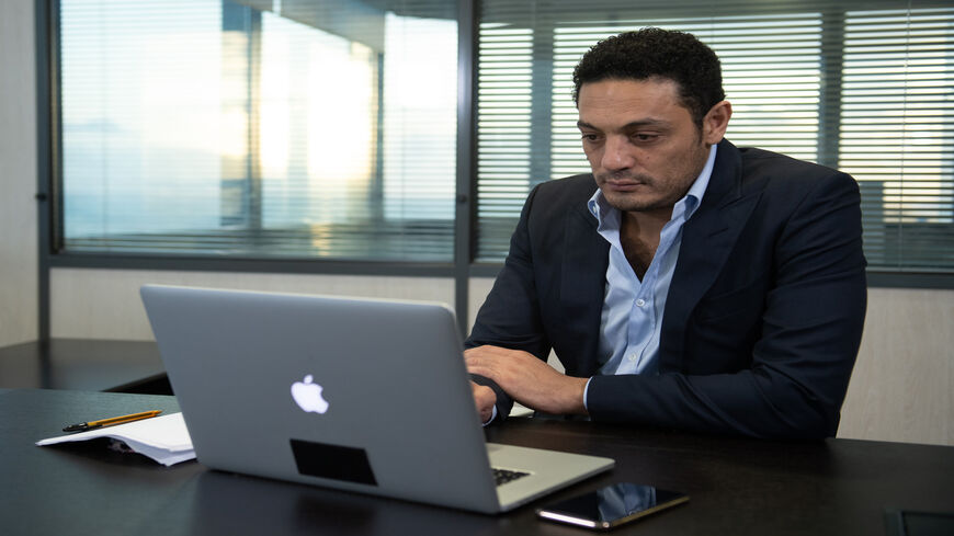 Egyptian self-exiled businessman Mohamed Ali looks at his laptop during an interview in an office near Barcelona, Spain, Oct. 23, 2019.