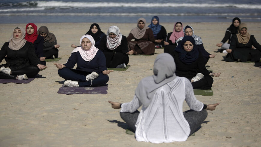 Palestinian women practise yoga on the beach during an event organized by the Positive Energy Club, Gaza City, Gaza Strip, March 3, 2020.