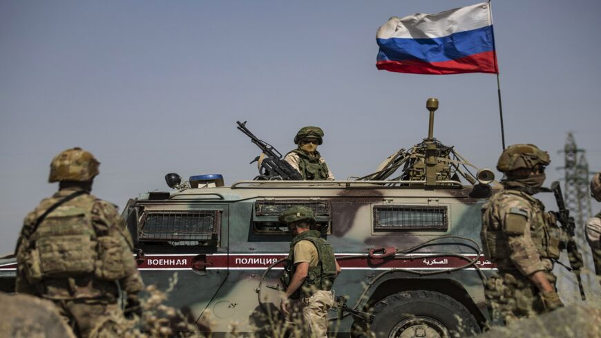 US soldiers stand near a Russian military vehicle in the Syrian town of al-Malikiyah (Derik), on June 3, 2020.