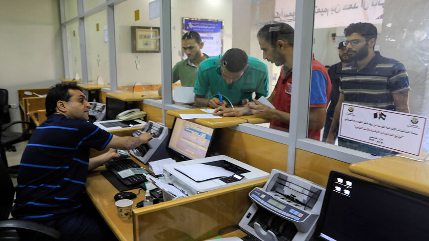 Palestinians receive their financial aid, $100 per needy family, offered by Qatar, at a post office in Gaza City, Gaza Strip, June 27, 2020.