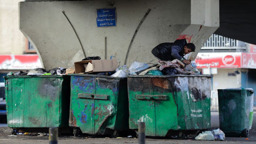 A boy digs in a garbage container in the Lebanese capital, Beirut, on Jan. 15, 2021.